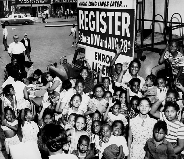 Group of African American children next to voting sign