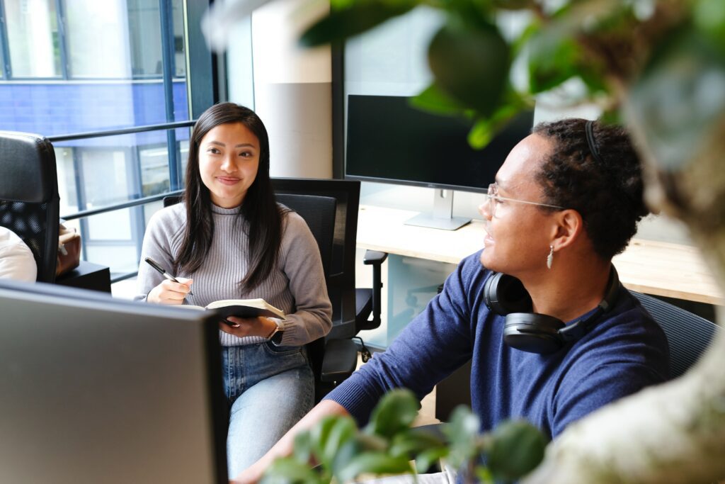 Two people smiling and working together. 