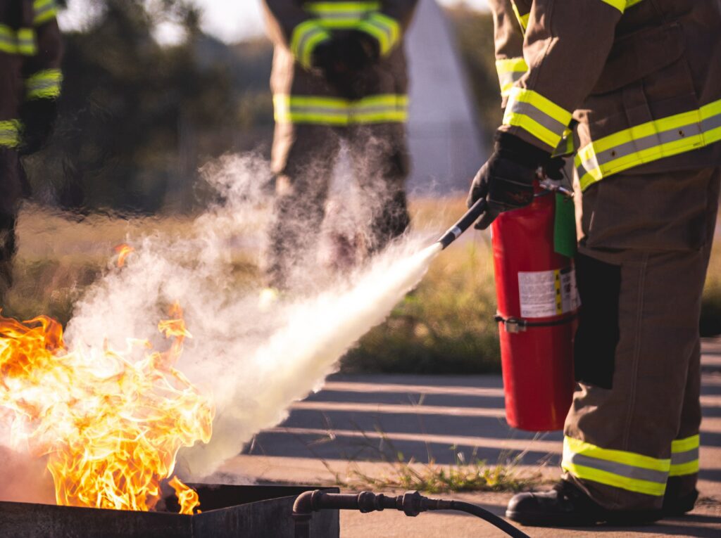 Fireman using extinguisher on fire. 