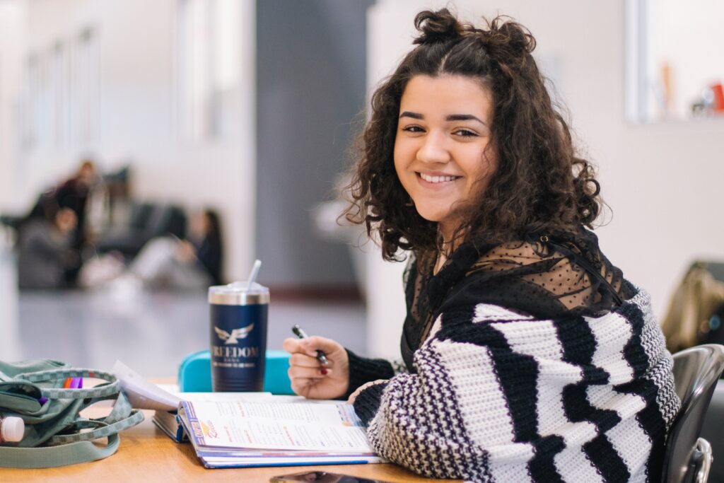 young woman smiling while studying.