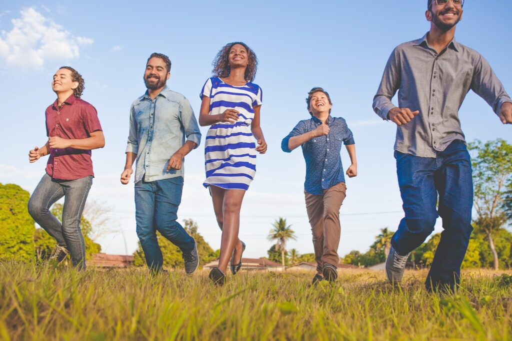 men and women running free in a field. 
