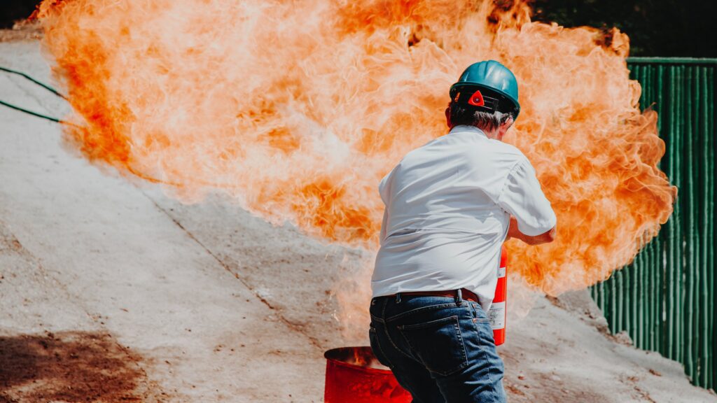 man putting out fire with extinguisher. 