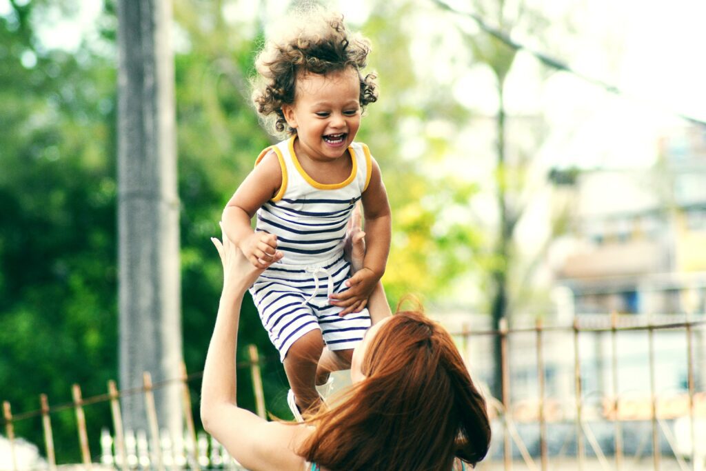 Mother playfully tossing child in the air.